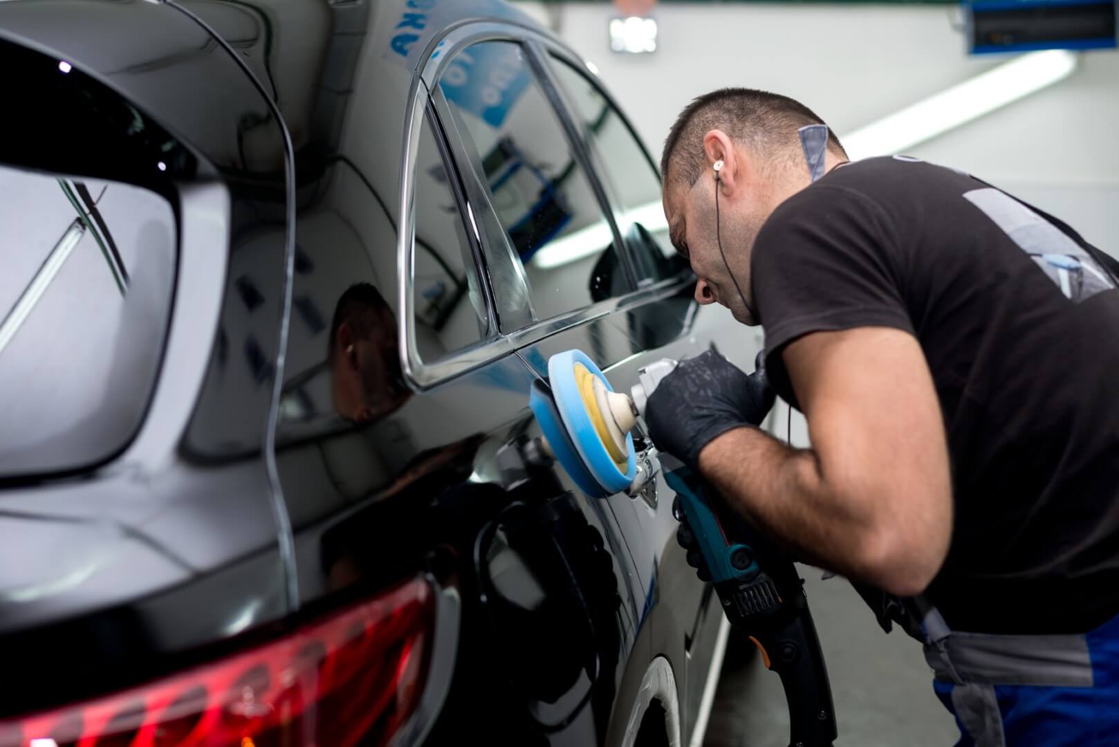 Car detailing expert from North York waxing a car.
